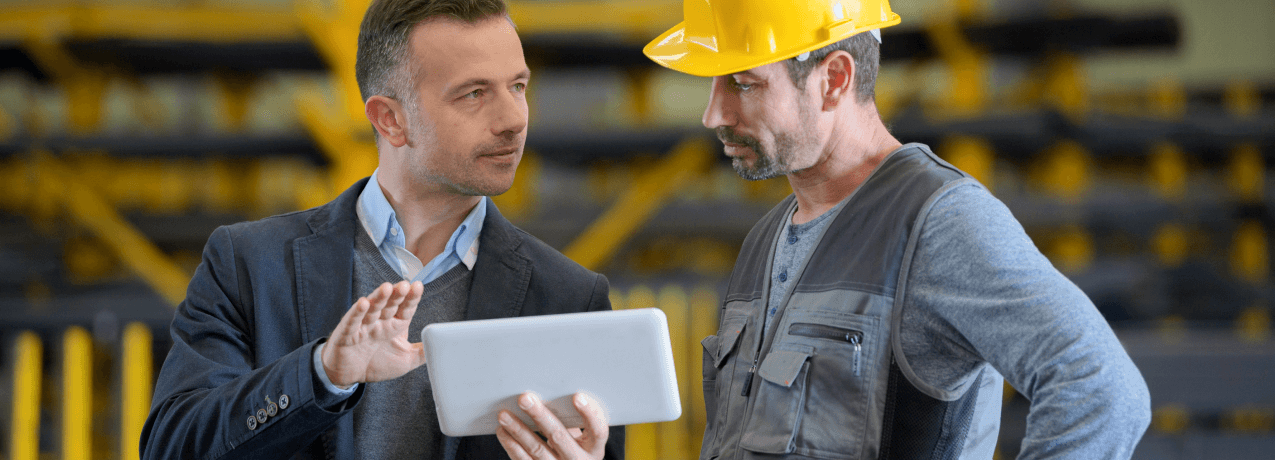 business man and construction worked looking at ipad together