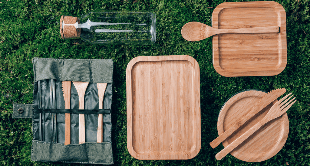 Reusable bamboo picnic set with plates, cutlery, and cutting board for eco-conscious summer outings.