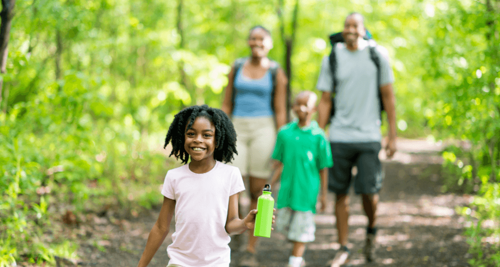 Family enjoying eco-conscious waste management in nature during summer.