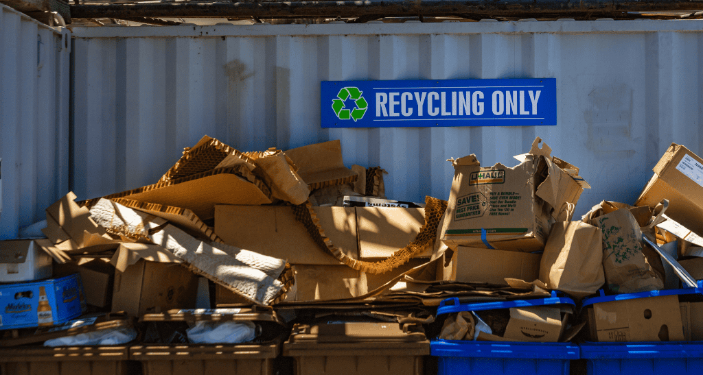 Recycling only sign with cardboard and paper waste for eco-friendly disposal.