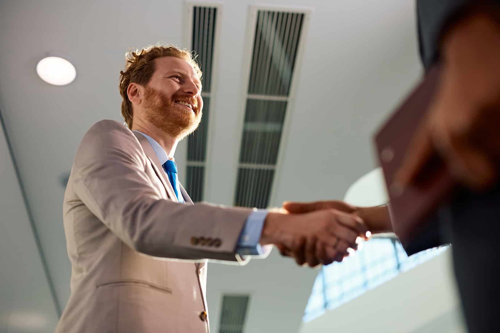 Business professional shaking hands, waste management solutions for SMBs.