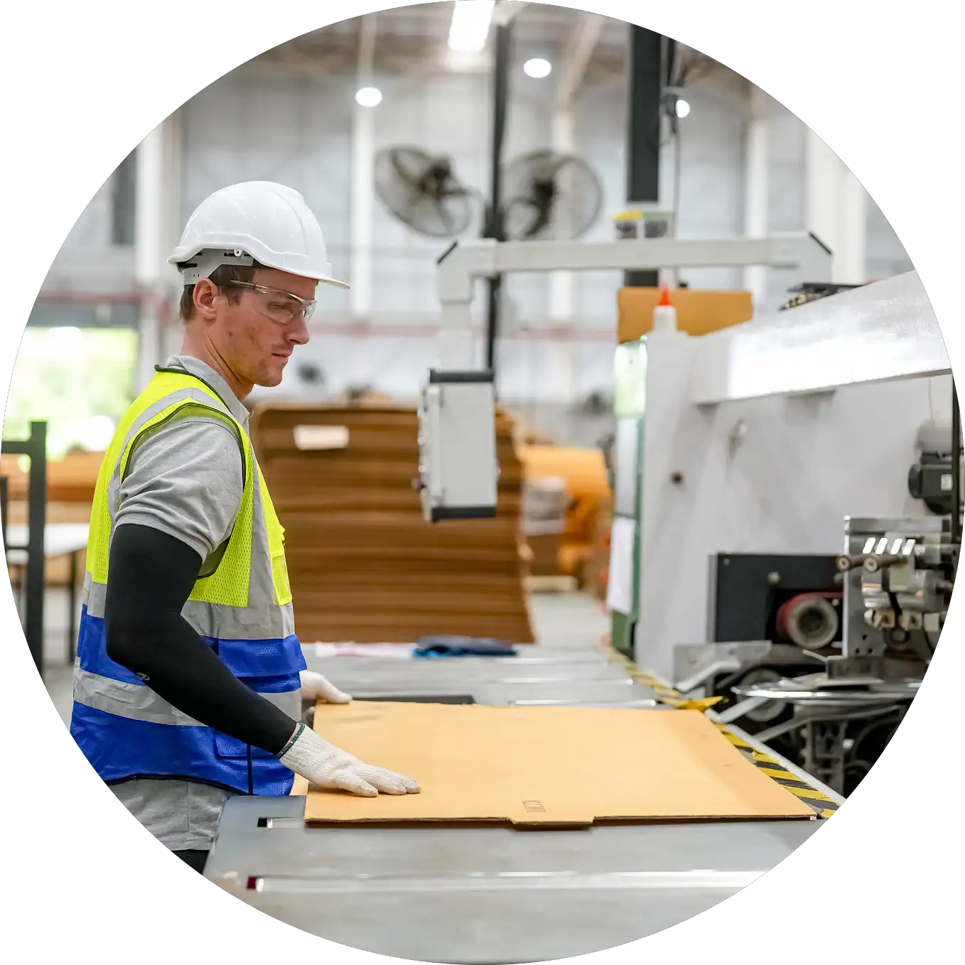 Manufacturing worker handling waste materials in factory setting.