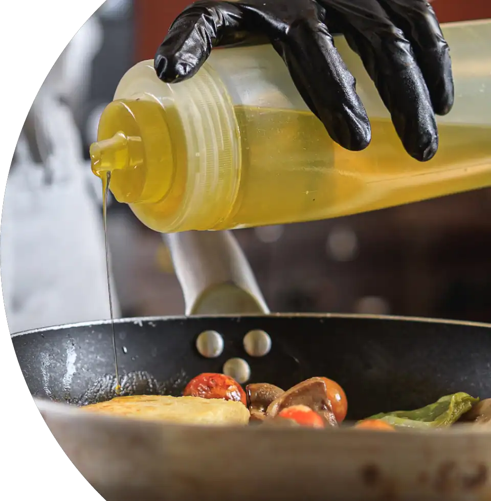 Used cooking oil being poured into a container for recycling.